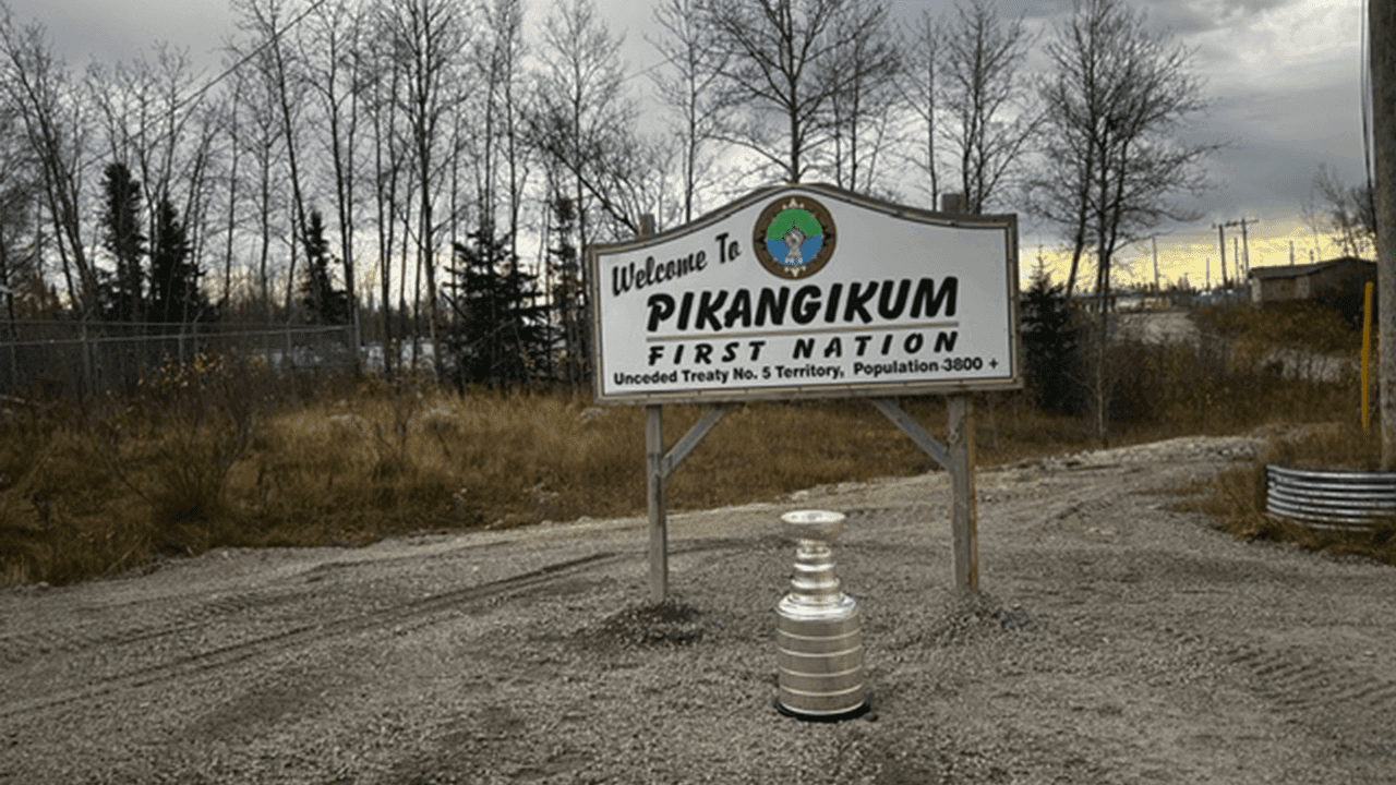 Stanley Cup in front of Pikangikum First Nation welcome sign