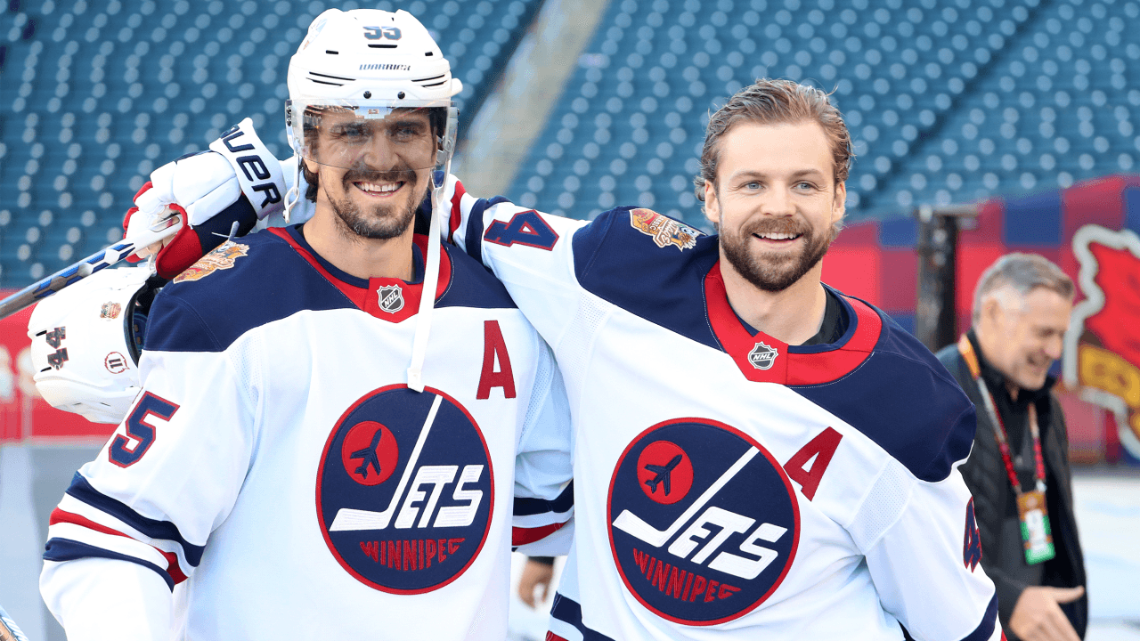 WINNIPEG, MANITOBA - OCTOBER 24: Mark Scheifele #55 and Josh Morrissey #44 of the Winnipeg Jets wait to take the ice prior to the team photo and before team practice for the 2026 NHL Heritage Classic at Princess Auto Stadium on October 24, 2026 in Winnipeg, Manitoba.