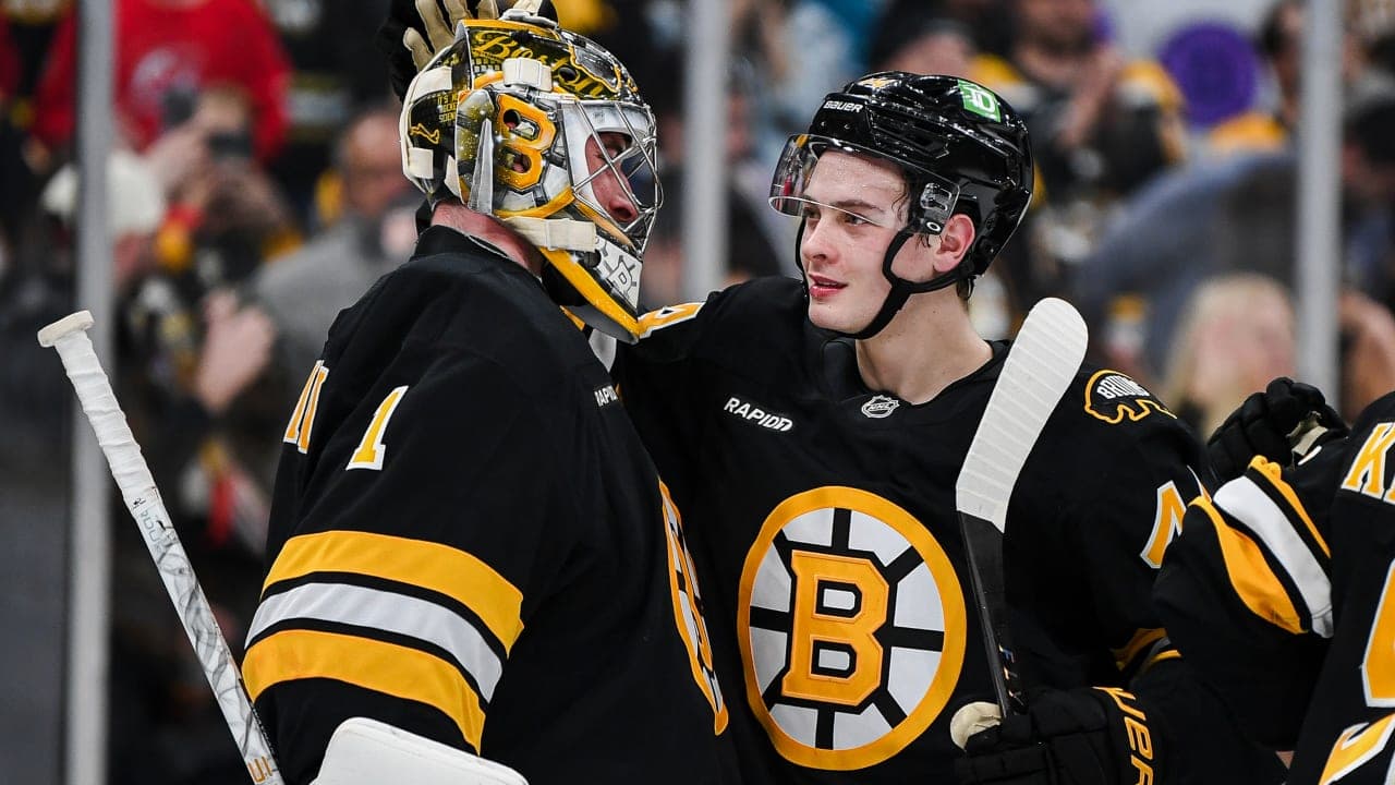 Jeremy Swayman #1 of the Boston Bruins celebrates a win with James Hagens #44