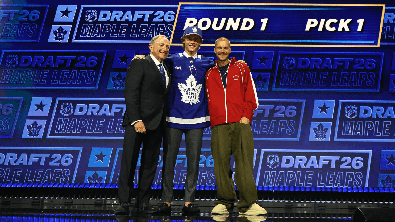 NHL commissioner Gary Bettman looks on as Gavin McKenna of Canada and singer Justin Bieber look on after McKenna was drafted by the Toronto Maple Leafs
